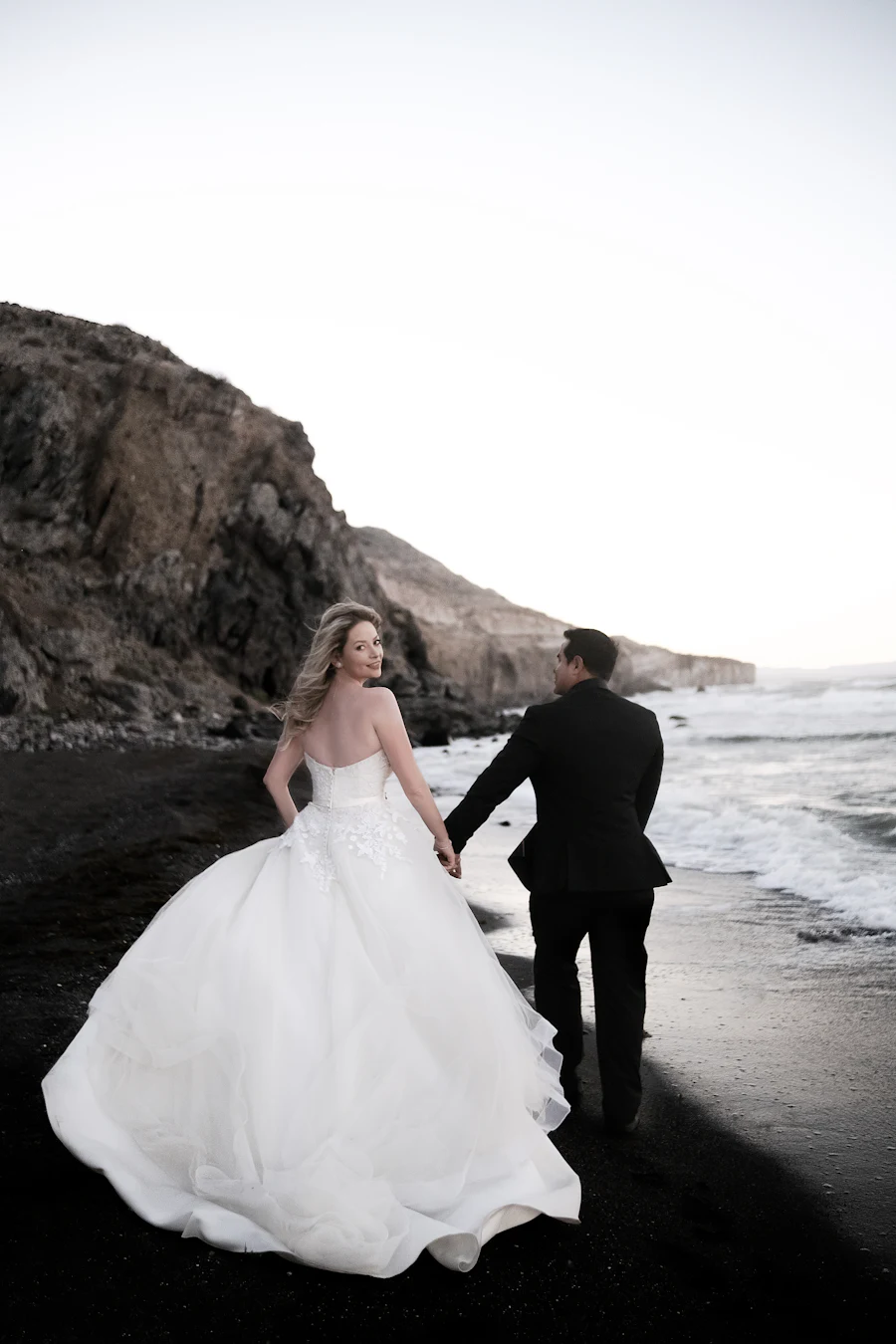 Los novios paseando por una playa